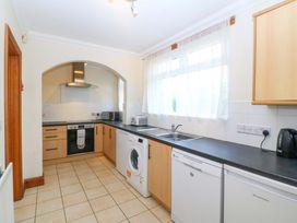 A kitchen with appliances and a sink at Cwm Eilir Criccieth