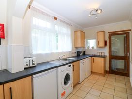 A kitchen with appliances and a window at Cwm Eilir in Criccieth