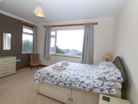 A bedroom with a bed and dressing table at Cwm Eilir Criccieth