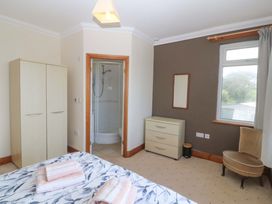 A bedroom with a wardrobe and a shower at Cwm Eilir in Criccieth