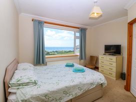 A bedroom with a bed and a dresser at Cwm Eilir in Criccieth
