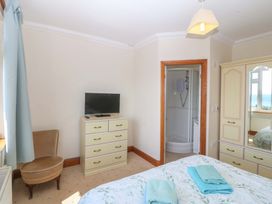 A bedroom with a bed and television at Cwm Eilir in Criccieth