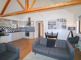 A living room with a sofa and dining area at Lodge 1 South Hykeham