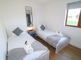 A bedroom with two single beds and a mirror at Lodge 1 South Hykeham