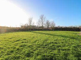 A garden with grass and trees at Lodge 1 South Hykeham