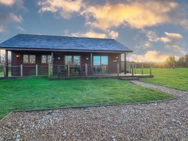 A cabin with a deck and a gravel pathway at Lodge 2 South Hykeham