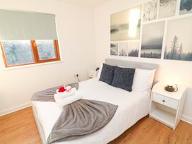 A bedroom with a bed and nightstand at Lodge 2 South Hykeham