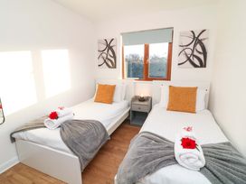 A bedroom with twin beds and window at Lodge 2 South Hykeham