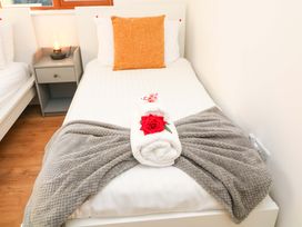 A single bed with a towel and rose on the blanket at Lodge 2 South Hykeham