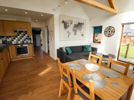 An open kitchen and dining area with wooden cabinets and a dining table with chairs at Lodge 3 in Thorpe-On-The-Hill