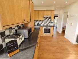 A kitchen with wooden cabinets a black countertop a microwave toaster and an oven at Lodge 3 in Thorpe-On-The-Hill