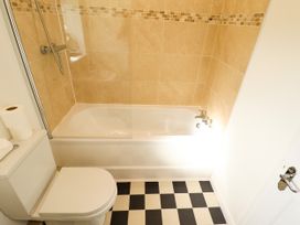 A bathroom with a toilet and bathtub with shower at Lodge 3 in Thorpe-On-The-Hill