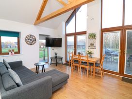 A living room with a sofa, coffee table, and dining area at Lodge 3 Thorpe-On-The-Hill