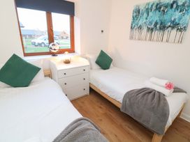 A bedroom with two beds and a dresser at Lodge 3 in Thorpe-On-The-Hill