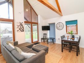 A living room with a sofa and dining table at Lodge 4 South Hykeham
