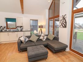 A living room with a sofa and kitchen in Lodge 4 South Hykeham