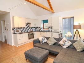 A living room and kitchen area with a sofa and kitchen units at Lodge 4 South Hykeham
