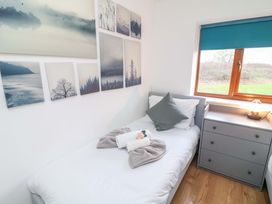 A bedroom with a single bed and wall art at Lodge 4 in South Hykeham