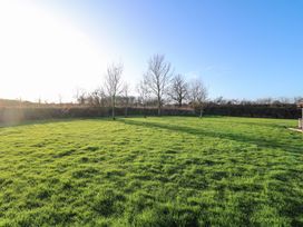 A garden with grass and trees at Lodge 4 in South Hykeham