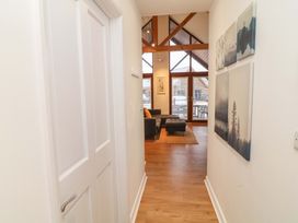 A hallway leading to a living area with large windows at Lodge 7 in South Hykeham