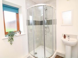 A bathroom with a shower, sink, and window at Lodge 7 in South Hykeham