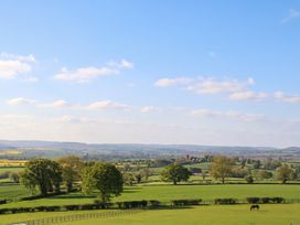 A landscape view with trees and a horse in a field at Palace Studio in St Weonards