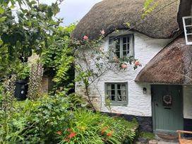 A thatched cottage surrounded by a garden at 4 Cumberland Cottages in Ringmore near Challaborough