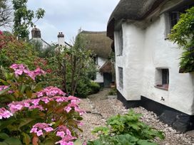 A cottage with a thatched roof and a garden at 4 Cumberland Cottages in Ringmore near Challaborough
