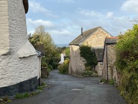 A view of a street lined with houses and trees at 4 Cumberland Cottages Ringmore near Challaborough