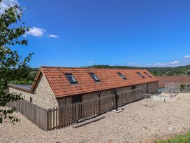 A building with a fenced area and gravel surrounding at The Stables in Uplyme