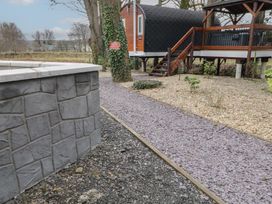 An outdoor area with a gravel pathway leading to a small elevated cabin with stairs and railing at Pine in Dungiven Londonderry