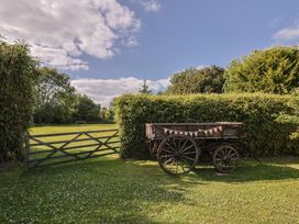 An outdoor scene with a wooden wagon and a gate at The Hay Loft in Colyton