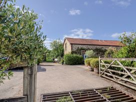 An outdoor area with a building and plants at The Hay Loft in Colyton