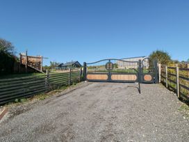 A gated entrance with a gravel driveway and play structure at Stags Mount in Thornton Dale