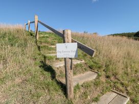 A sign indicating a dog exercise field with a path at Stags Mount in Thornton Dale