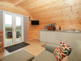 A living room with a sofa and kitchen unit at Holly in Ulverston