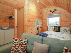 A bedroom with a bed and kitchenette at Holly in Ulverston