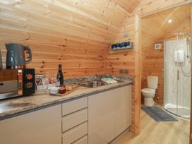 A kitchen area with appliances and a bathroom at Holly in Ulverston