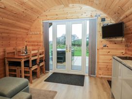 A dining area with a table and chairs and a sliding door at Willow in Ulverston