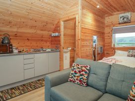 A bedroom with a kitchen area and sofa at Willow in Ulverston