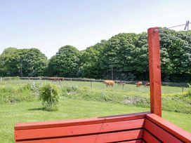 A field with cows grazing and trees in the background at Willow in Ulverston