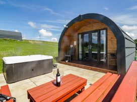 An outdoor seating area with a hot tub and table at Oak in Ulverston