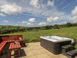 An outdoor area with a hot tub and seating at Oak in Ulverston