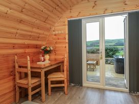 A dining area with a table and chairs overlooking a patio at Rowan Ulverston