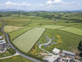 An aerial view of farmland with fields and buildings at Rowan in Ulverston