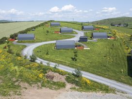 An outdoor area with cabins and a gravel road at Rowan in Ulverston