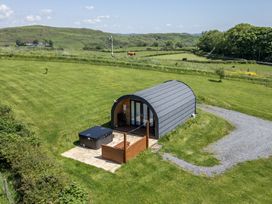 A house with a hot tub and decking on a grassy area at Rowan in Ulverston