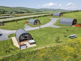 An outdoor area with cabins and a hot tub at Rowan in Ulverston