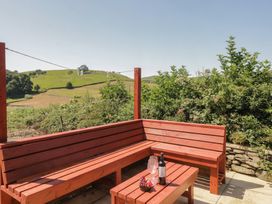An outdoor seating area with a table and bench at Rowan in Ulverston