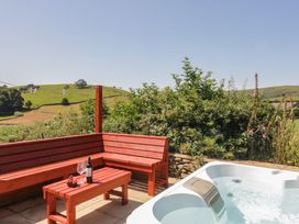 An outdoor space with a hot tub and seating area at Rowan in Ulverston